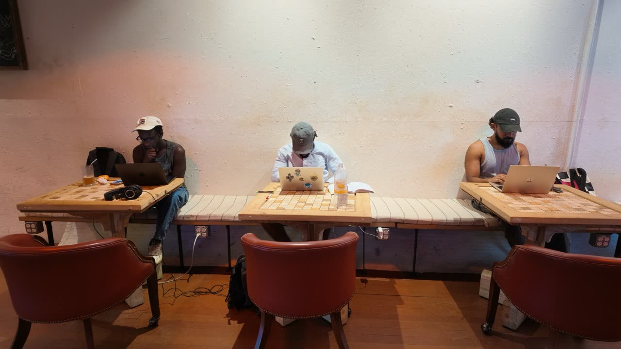 Three members working at a long shared table in the MAKRSLAB room, laptops open.